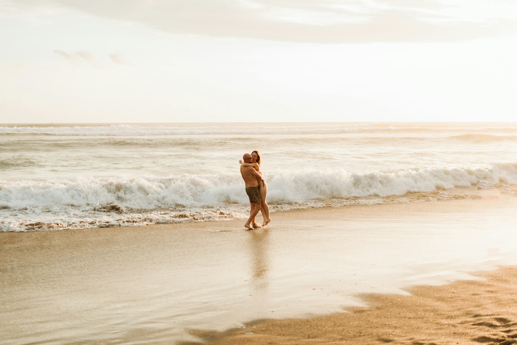 Couple embracing on a sunlit tropical beach